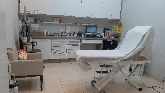 Consultório da Clínica Wulkan na unidade Osasco, com maca de procedimentos e bancada de materiais